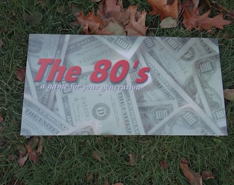 May include: A game box with a background of US dollar bills. The box is white with a red title that reads "The 80's" and the subtitle "a game for your generation".