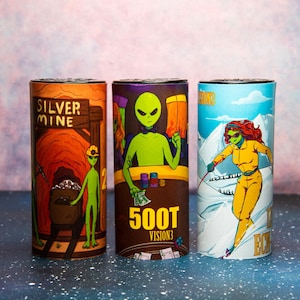 May include: Three cylindrical containers with colorful illustrations. One features an alien in a mine with the text "SILVER MINE". Another shows an alien at a poker table with the text "500T VISION3". The last depicts an alien skier with the text "VISIONS3".