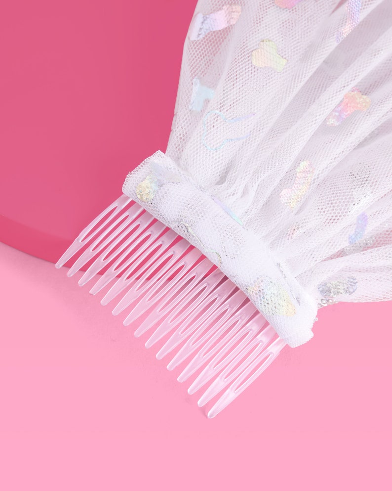 Peut inclure: Voile en tulle blanc avec des paillettes iris&eacute;es et un peigne en plastique transparent. Le voile est attach&eacute; au peigne.