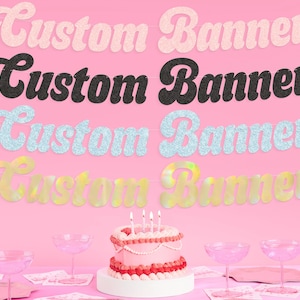 May include: Four custom banners in pink, black, light blue, and yellow, each with the words "Custom Banner". A pink cake with candles and pink glasses are in the foreground. The background is a solid pink color.