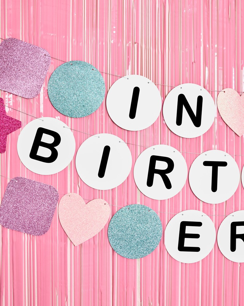 May include: A pink and white glitter birthday banner with the words "Happy Birthday" in black letters.