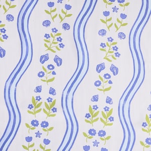 May include: White fabric with a repeating pattern of blue wavy stripes, seashells, flowers, and stars. The flowers and seashells are blue, and the leaves are green. The design is reminiscent of a coastal theme.