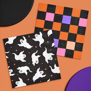May include: Two Halloween-themed paper napkins. One features white ghosts on a black background with stars. The other has a checkerboard pattern in orange, pink, purple, and black. Perfect for a spooky party.
