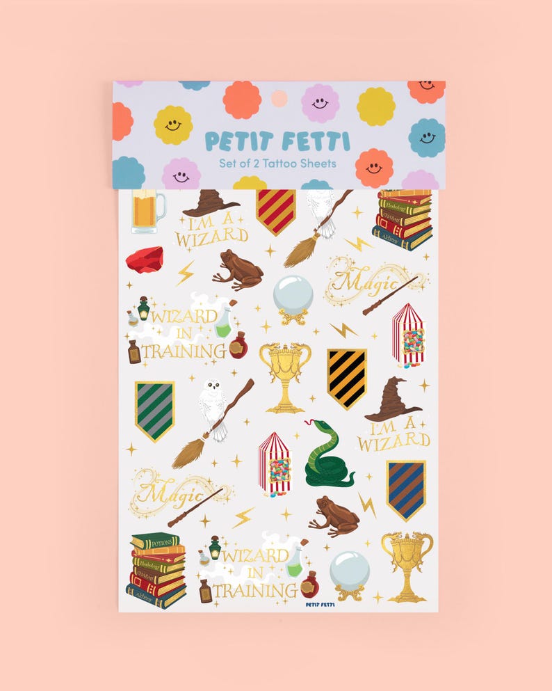 May include: Set of two tattoo sheets featuring wizard-themed illustrations. Designs include a wizard hat, broom, books, a frog, a snake, and the text "I'M A+ WIZARD" and "WIZARD IN TRAINING". The top of the sheet has colorful smiley face designs.