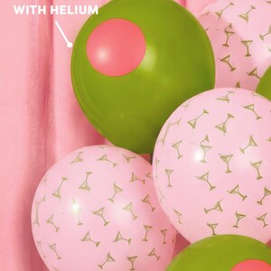 May include: A cluster of party balloons in shades of green and pink. Some balloons are olive green with a pink circle, resembling olives. Others are pink with a gold martini glass pattern. Text on the image reads: "WILL ONLY FLOAT IF FILLED WITH HELIUM."