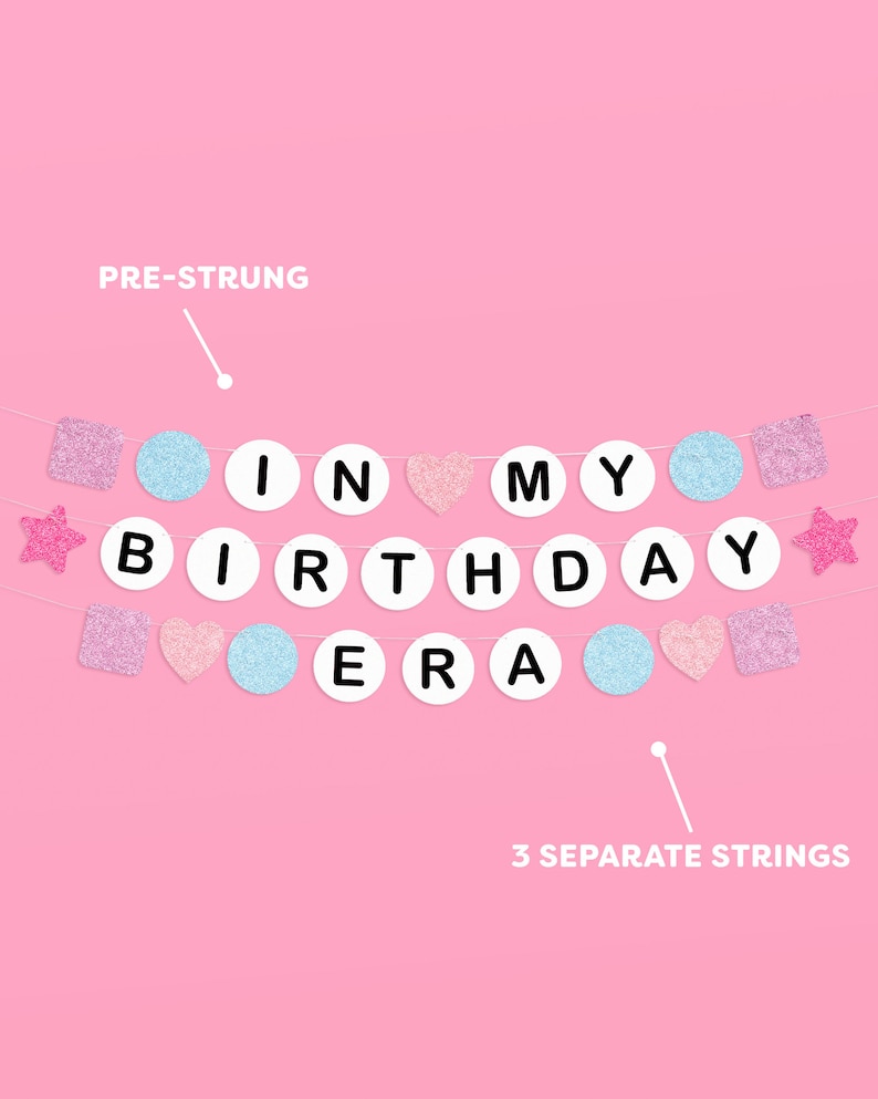 May include: A pink and blue pre-strung banner with the words "In My Birthday Era" in white letters on white circles. The banner includes pink and blue glitter stars, hearts, and squares.