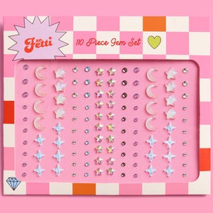 May include: A pink and white card with a pink and white checkered background. The card has a white diamond in the bottom left corner and the text "110 Piece Gem Set" in the top right corner. The card is filled with small, colorful gems in the shape of stars, moons, and circles.