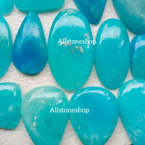 Puede incluir: Una colecci&oacute;n de cabujones turquesa, algunos de forma ovalada y otros en forma de l&aacute;grima, sobre un fondo blanco. Los cabujones tienen una apariencia transl&uacute;cida y vidriosa. El texto "Allstoneshop" aparece dos veces en la imagen.