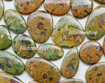 May include: A collection of 14 green, brown, and orange polished ocean jasper cabochons. The cabochons are various shapes and sizes, with a variety of patterns and textures. Allstoneshop is printed on the image.