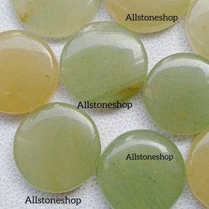 May include: A collection of smooth, polished green and yellow stones. The stones are round and have a natural, organic look. The stones are labeled "Allstoneshop".