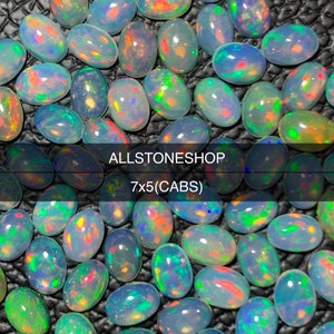 Könnte beinhalten: Eine Sammlung ovaler Opale mit lebendigen, irisierenden Farben. Die Opale zeigen eine Mischung aus Blau, Grün, Orange und Rot. Der Text "ALLSTONESHOP" und "7x5(CABS)" sind sichtbar. Diese Opale eignen sich für die Schmuckherstellung.
