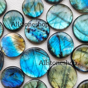 Könnte beinhalten: Sortiment runder, irisierender Labradorit-Cabochons in Blautönen, Grün und Gold. Die Steine haben eine schimmernde, opaleszierende Qualität. Allstoneshop.
