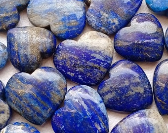 Puede incluir: Una colección de piedras de lapislázuli pulidas en forma de corazón con inclusiones de pirita dorada. Las piedras son de un azul profundo con vetas blancas y doradas.