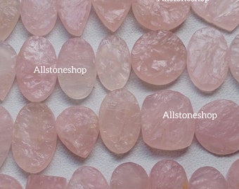 May include: A collection of 20 pink rose quartz cabochons, each with a unique shape and texture. The stones are all natural and have a beautiful, translucent quality. Allstoneshop is printed on the image.