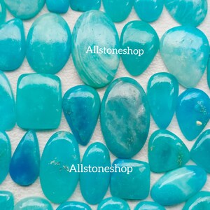 Puede incluir: Una colecci&oacute;n de piedras preciosas cabuj&oacute;n de color azul turquesa y blanco. Las piedras son de varias formas y tama&ntilde;os, incluyendo ovaladas, en forma de l&aacute;grima y cuadradas. Todas las piedras est&aacute;n pulidas y tienen un acabado liso y brillante. Allstoneshop est&aacute; escrito en la imagen.