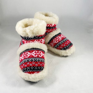 Puede incluir: Par de zapatillas de estar por casa de forro polar con estampado rojo, blanco y gris y pu&ntilde;o blanco.