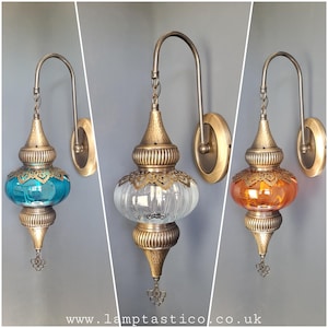 May include: Three wall sconces with ornate brass fixtures and glass shades. The shades are clear, teal blue, and amber.