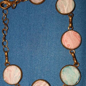 Light weight, hand painted antique bronze finished bracelet in pink, white, silver and turquoise.