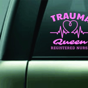 May include: Pink vinyl sticker with the text "Trauma Queen Registered Nurse" and a pink heart with a heartbeat graphic.