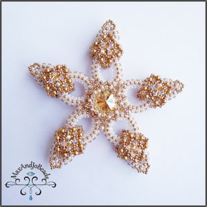 May include: A white and gold beaded snowflake ornament with a clear crystal in the center.