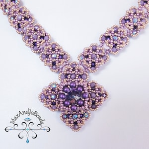 Könnte beinhalten: Eine violette und goldene Perlenkette mit einem großen violetten Kristallanhänger. Die Kette ist aus kleinen Perlen gefertigt und hat ein zartes Blumenmuster.