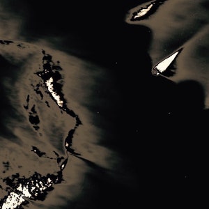 May include: Abstract black and white image with a textured, wrinkled surface. The image has a dark, shadowy feel with light areas that appear to be glowing.