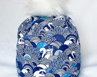 WILDWAYS - Alpine or Nordic Style Hat,  Blue and white 4 way stretch poly spandex with lightweight fleece ear band and Pompom.