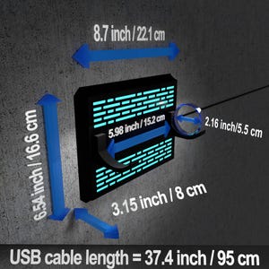 May include: Black rectangular device with a grid pattern and blue lighting. Dimensions are indicated with blue arrows: 8.7 inches/22.1 cm wide, 6.54 inches/16.6 cm high, and 5.98 inches/15.2 cm across. USB cable length is 37.4 inches/95 cm.