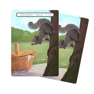 May include: Two illustrated cards featuring a gray squirrel climbing a tree, with a picnic basket in the background. The cards have the text "Token Creature - Squirrel" and "1/1" at the top. The artwork has a whimsical, outdoorsy theme.