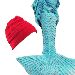 May include: A blue and green mermaid tail blanket with a red knit beanie hat. The blanket is made of a soft, knitted fabric and features a mermaid tail design. The beanie hat is a warm and cozy accessory.
