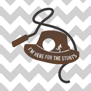 Puede incluir: Sombrero de fieltro marrón con un lazo y el texto "I'm here for the stunts".