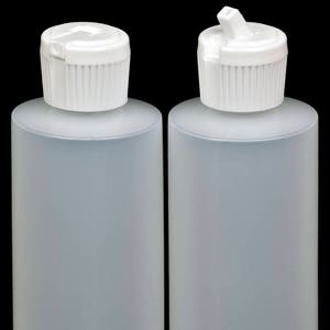 May include: Two clear plastic bottles with white flip top caps. The bottles are empty and have a frosted finish.