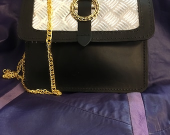 a small handbag in leather with cold chain and stainless steel look