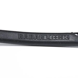 May include: Close-up of a black sunglass arm with the text "RADARLOCK" embossed on a textured rubber grip. The arm has a glossy black finish and a sleek, modern design.