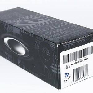 May include: A black rectangular box with a silver oval logo and a white label with a barcode. The box has a patterned design and the text "Oph. Yarddog II (53) Satin".