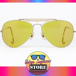 K&ouml;nnte beinhalten: Goldene Aviator-Sonnenbrille mit gelben Gl&auml;sern. Die Sonnenbrille hat einen Metallrahmen und ist in gutem Zustand.