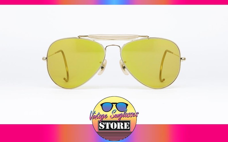K&ouml;nnte beinhalten: Goldene Aviator-Sonnenbrille mit gelben Gl&auml;sern. Die Sonnenbrille hat einen Metallrahmen und ist in gutem Zustand.