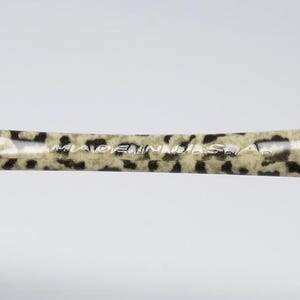 May include: A hair styling tool with a leopard print pattern in tan and black. The text "MADE IN U.S.A." is printed in white on the surface of the tool.