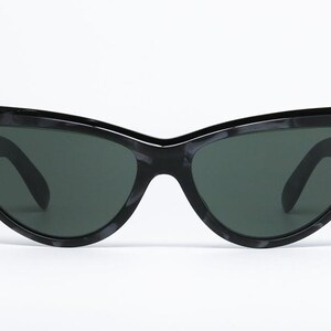 May include: Black cat-eye sunglasses with a tortoise shell pattern on the frame.