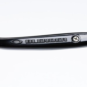 Puede incluir: Primer plano de una patilla de gafas negra con la palabra "BLENDER" grabada en relieve en el lateral. La patilla tiene un dise&ntilde;o curvado y un peque&ntilde;o tornillo cerca de la bisagra. Las gafas son probablemente para la correcci&oacute;n de la visi&oacute;n o la moda.