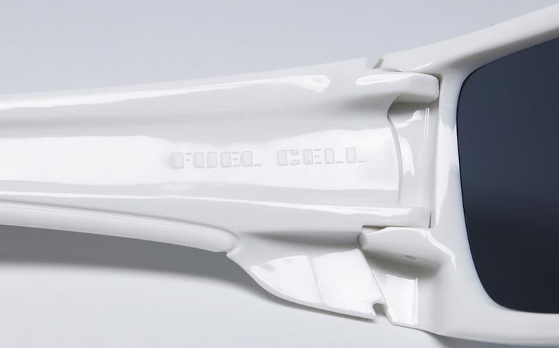 May include: White sunglasses with dark lenses. The frame has a glossy finish and the text "DEDOD.O CELL" is embossed on the temple. The sunglasses are designed with a sporty, streamlined aesthetic.