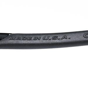 May include: Close-up of a black eyewear frame with the text "MADE IN U.S.A." and the CE mark. The frame is made of a matte black material and has a curved design. The image is set against a white background.