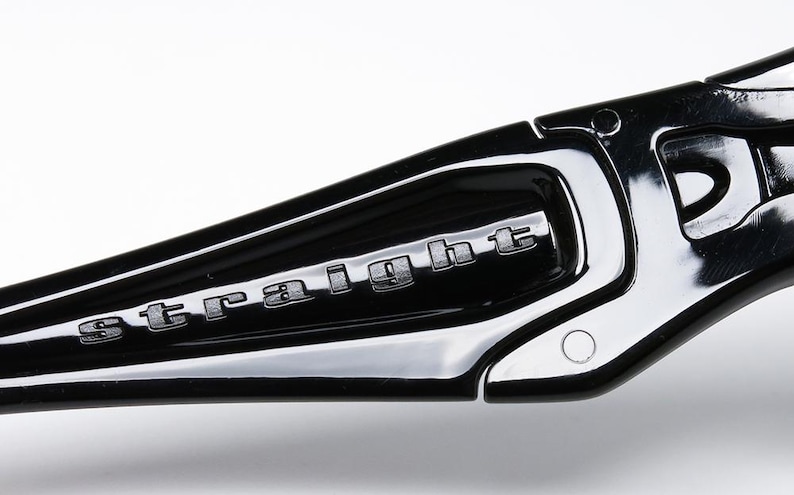 May include: Close-up of a black, glossy eyeglass frame arm with the word "straight" embossed in silver lettering. The frame has a sleek, modern design with a reflective surface.
