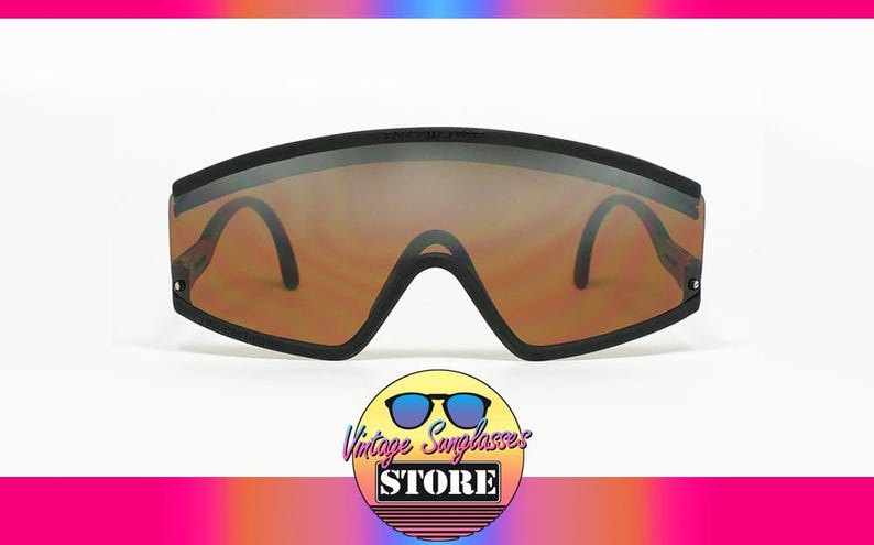 Op de afbeelding: Zwarte vintage zonnebril met bruin getinte glazen. De zonnebril heeft een breed, rechthoekig montuur en een brug die naar beneden buigt. De pootjes zijn dun en zwart. Het logo van Vintage Sunglasses Store staat onderaan.