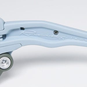 May include: Close-up of light blue sunglasses with the text "Racing jacket" on the arm. The sunglasses have a gray hinge and dark lenses. The frame is a matte finish.