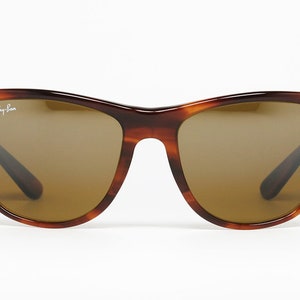 Peut inclure: Une paire de lunettes de soleil Ray-Ban en &eacute;caille de tortue brune avec des verres bruns.