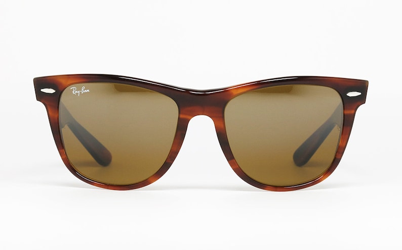 Peut inclure: Une paire de lunettes de soleil Ray-Ban en &eacute;caille de tortue brune avec des verres bruns.