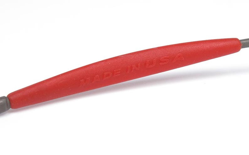 May include: A red tool with the text "MADE IN USA" printed on the handle. The tool has a gray tip on each end. The handle is a bright red color.