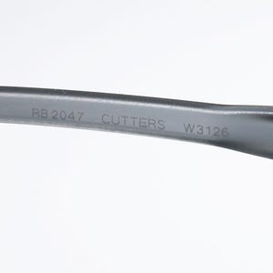 May include: Close-up of a gray eyeglass arm with the text "RB 2047 CUTTERS W3126" printed in white. The arm is curved and appears to be made of plastic or a similar material. The background is plain white.