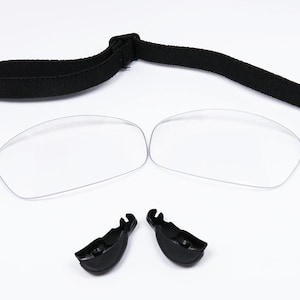 Puede incluir: Un par de gafas transparentes con una correa negra y dos piezas de pl&aacute;stico negro. Las gafas est&aacute;n dise&ntilde;adas para usarse sobre gafas de prescripci&oacute;n.